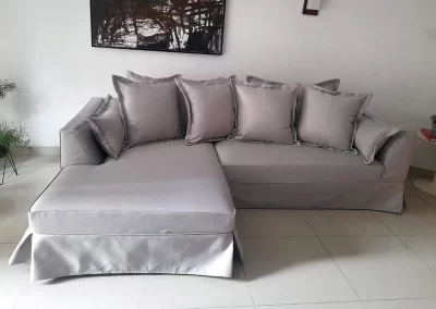 Sofá com chaise, capa confeccionada em tecido linho e detalhe com saia e abas nas almofadas